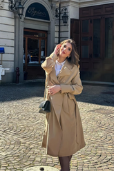 a lady wears a classic beige trench coat